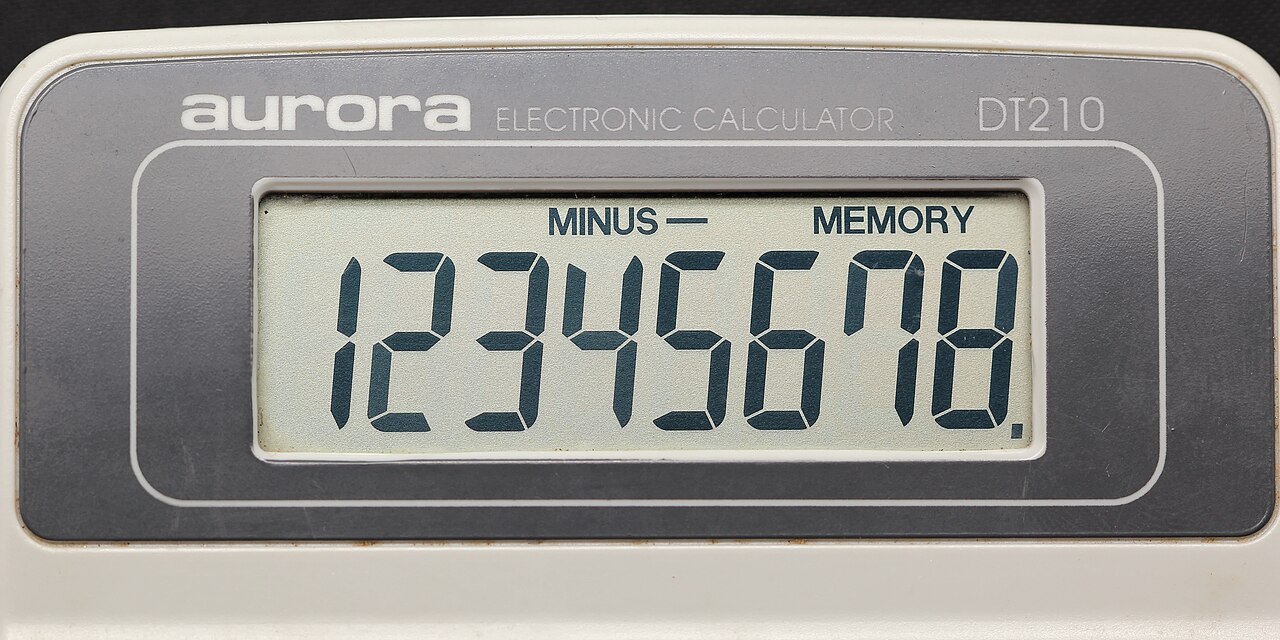 Working out numbers on paper beside a phone